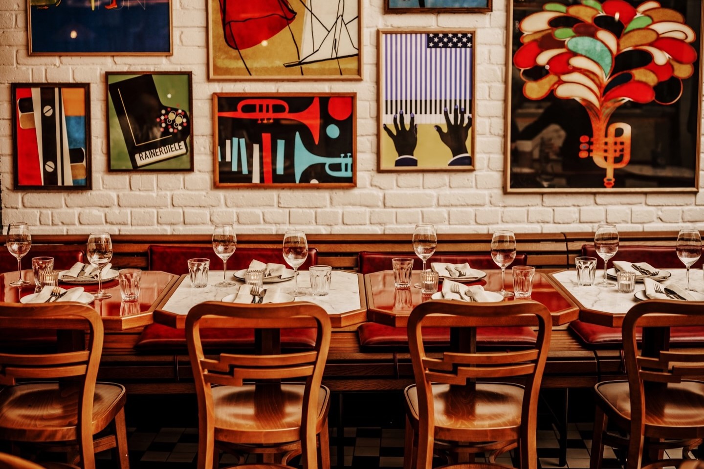 Restaurant interior with patterned floor, wooden furniture, and decorative lighting